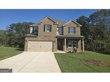 Brick two-story house with a two-car garage at 5696 Laney Dr, Rex, GA 30273
