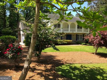 Two-story house with a large front yard, mature trees, and a long driveway at 2692 Peppermint Dr, Tucker, GA 30084