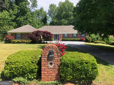 Brick ranch house with attached garage and manicured lawn at 3572 Stone Ridge Trl, Douglasville, GA 30134