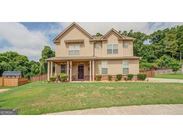 Two story house with tan siding and a large yard at 445 Brickstone Way, Covington, GA 30016
