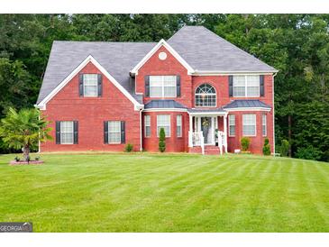 Two-story brick house with a landscaped lawn and mature trees at 132 Sunflower Meadows Dr, Mcdonough, GA 30252