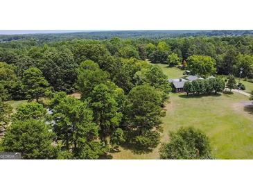 Aerial view of house and expansive wooded lot at 1092 Harbins Rd, Dacula, GA 30019