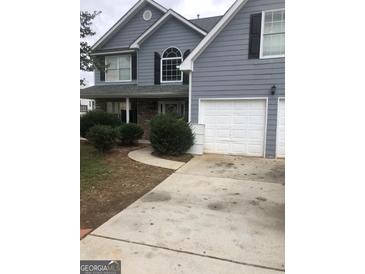 Two-story gray house with double garage and landscaping at 25 Franklin Way, Covington, GA 30016