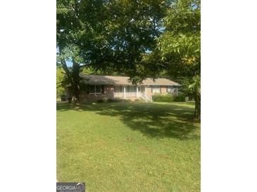 Ranch-style home with front porch and lawn at 1112 Harbins Rd, Dacula, GA 30019