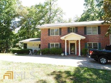 Brick house with a two-car driveway and landscaping at 573 Lester Rd, Fayetteville, GA 30215