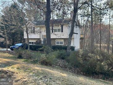 Two-story house with attached garage and wooded setting at 2129 Kings Mountain Dr., Conyers, GA 30012