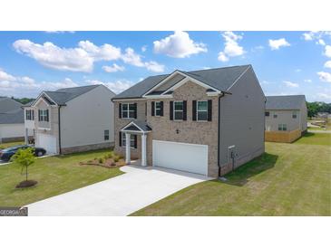 Two-story house with gray siding and a two-car garage at 536 Whitman (Lot 2010) Ln # 2010, Stockbridge, GA 30281