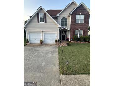 Two-story house with brick and siding, two-car garage, and landscaped yard at 133 Ventura Trl, Stockbridge, GA 30281