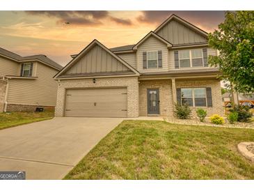 Two-story house with brick and siding, double garage, and front yard at 1223 Hartwell Rd, Locust Grove, GA 30248