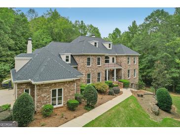 Brick house with a three-car garage and a large backyard at 100 Wesleyan Way, Oxford, GA 30054