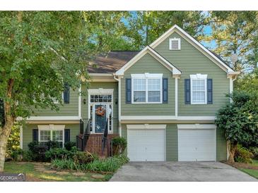 Green two-story house with two-car garage and landscaped yard at 4950 Abbotts Glen Nw Trl, Acworth, GA 30101