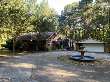 Brick ranch home with circular driveway, fountain, and detached garage at 4112 Jodeco Rd, Stockbridge, GA 30281