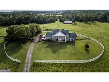 Aerial view of house on large lot with circular driveway and white fence at 1530 Highway 11, Mansfield, GA 30055