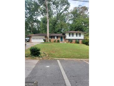 Ranch style house with attached garage and mature trees at 1999 Lindsey Ln, Decatur, GA 30035