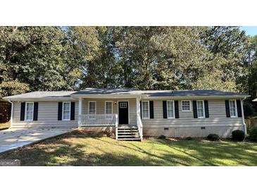 Ranch style home with light beige siding, a covered porch, and landscaping at 3869 Rosedale Ln, Douglasville, GA 30135