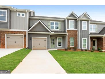 Brick and gray siding townhouse exterior with two-car garage at 1923 School House Ln, Temple, GA 30179