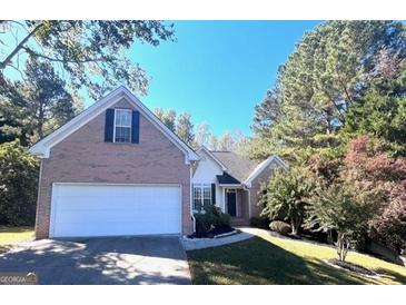 Brick house with a two-car garage and well-manicured lawn at 938 Mulberry Fields Cv, Auburn, GA 30011