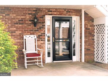 Front door entrance with rocking chair and brick facade at 12 Intown Pl, Fayetteville, GA 30214