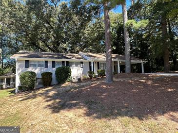 Charming ranch home with mature landscaping and a covered porch at 4466 Merlin Dr, Douglasville, GA 30134