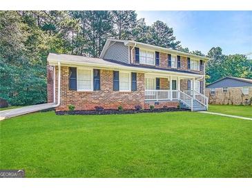 Two-story brick home with a gray roof and landscaped lawn at 382 Barbashela Dr, Stone Mountain, GA 30088