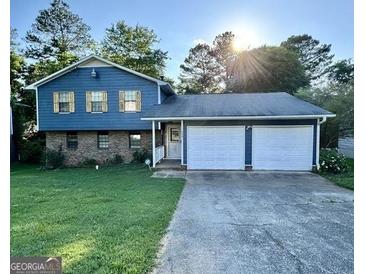 Two-story blue house with double garage and well-maintained lawn at 6091 Katherine Rd, Rex, GA 30273