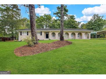 Brick ranch house with carport and yard at 3617 Collins Dr, Douglasville, GA 30135