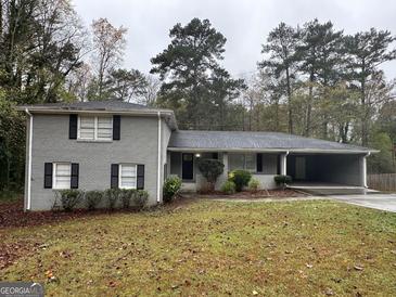 Gray brick house with attached carport and landscaping at 2929 Stratford Mill Rd, Lithonia, GA 30038