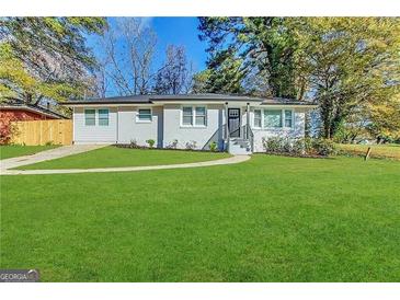 Modern white ranch house with a red door and manicured lawn at 3168 Mcafee Rd, Decatur, GA 30032