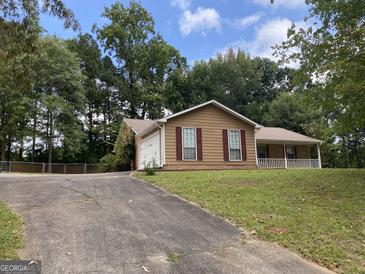 Ranch-style home with a carport and well-maintained lawn at 416 Winterwood Dr, Stockbridge, GA 30281
