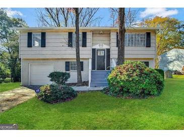 Two-story home with attached garage and landscaping at 6410 Buckhurst Trl, Atlanta, GA 30349