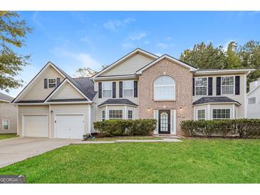 Two story house with two car garage and manicured lawn at 7546 Petal Pl, Fairburn, GA 30213