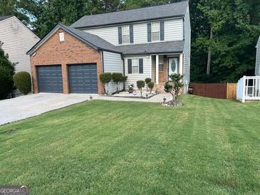 Two-story brick home with a two-car garage and landscaped lawn at 1004 Alford Ct, Lithonia, GA 30058