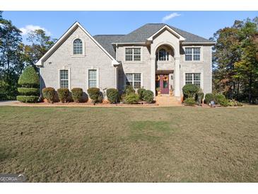 Two-story brick home with a grand entrance and manicured lawn at 2202 Escalade Ct, Conyers, GA 30094