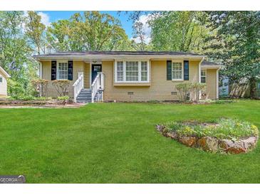 Ranch style home with landscaped yard and a white picket fence at 2413 Ben Hill Rd, East Point, GA 30344