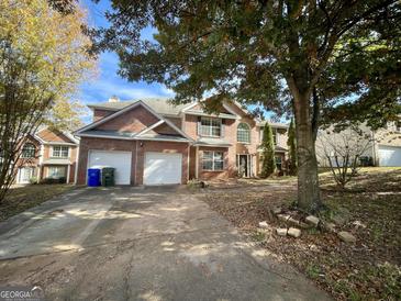 Brick house with two-car garage and landscaping at 1529 Evergreen Hollow Ln, Conyers, GA 30012