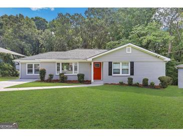 Charming ranch home with gray siding, red door, and well-manicured lawn at 2658 Rollingwood Se Ln, Atlanta, GA 30316