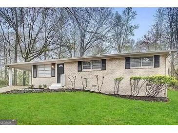 Ranch style home with brick facade, and a spacious lawn at 4906 Springbrook Dr, Douglasville, GA 30135