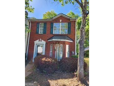 Brick townhouse exterior with green shutters, landscaping, and a walkway at 3044 Waldrop Cir, Decatur, GA 30034