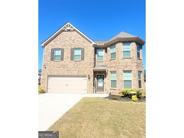 Two-story brick home with attached garage and landscaped lawn at 116 Jodi Pl, Locust Grove, GA 30248