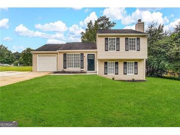 Two-story house with attached garage and manicured lawn at 4982 Millstone Walk, Stone Mountain, GA 30088
