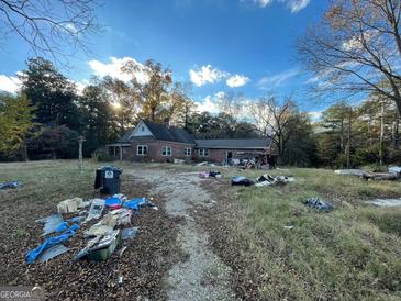 Brick house with overgrown yard needing landscaping at 43 Thurman Rd, Stockbridge, GA 30281