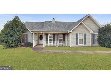 One-story house with gray siding, a covered porch, and a landscaped lawn at 231 Ferguson Ave, Locust Grove, GA 30248