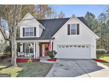 Two-story house with white siding, red brick accents, and a two-car garage at 409 St Dunstans Ct, Peachtree City, GA 30269