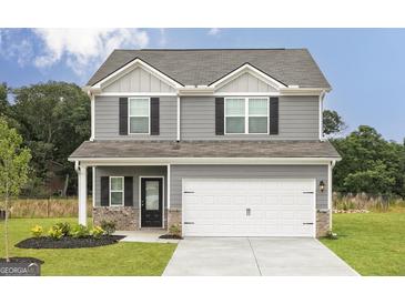 Two-story house with gray siding, white garage door, and landscaping at 133 Avondale Blvd, Conyers, GA 30013