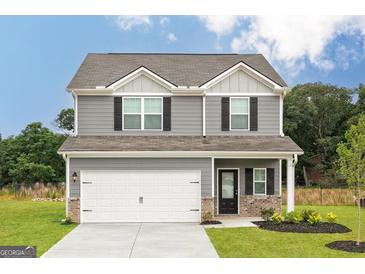 Two-story house featuring gray siding, a white garage door, and landscaping at 111 Avondale Blvd, Conyers, GA 30013