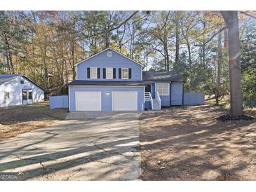 Cute blue house with a two-car garage and a spacious yard at 6864 Fielder Rd, Rex, GA 30273