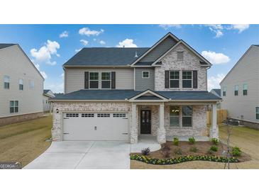 Two-story brick home with a large front yard and attached two-car garage at 1705 Goodwin Dr, Hampton, GA 30228