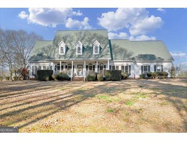 Two-story house with green roof, white siding, and large front porch at 2800 S Highway 16, Carrollton, GA 30116
