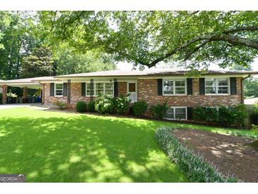 Brick ranch house with a large front yard and mature trees at 2872 Cartwright Drive Dr, Decatur, GA 30033