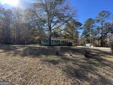 Ranch home with a large yard and mature trees at 870 Fincher Rd, Covington, GA 30016